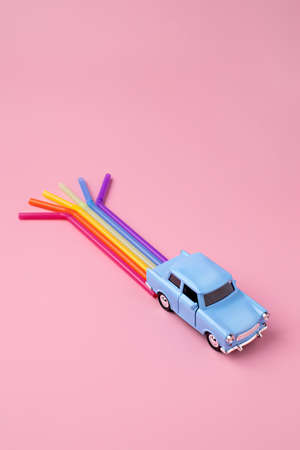 Blue car toy with rainbow trail make from straws. Minimal pop art travel concept. Flat lay.の写真素材