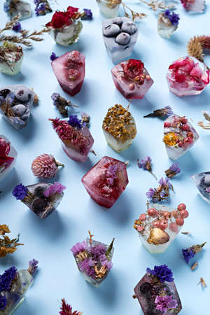 Creative layout made with fruit ice cubes, organic berries and dried flowers. Minimal summer concept. Flat lay.の写真素材