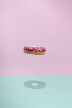 Donuts flying over a blue and pink background. Minimal bakery, baking concept. Levitation.