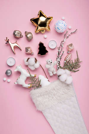 Creative layout made with Christmas socks with gifts and decorative ornaments on pastel pink background. Top view, flat lay.の写真素材