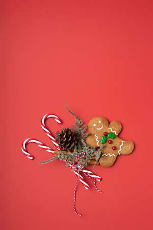 Creative New Year layout made with gingerbread man, cinnamon, Santa's cap and candy cane on red...