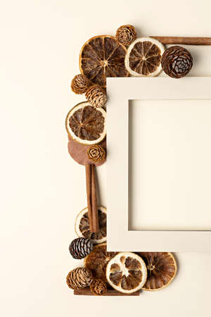 Creative Fall mock up frame made with dried lemons, pine cones and vanilla sticks on pastel...