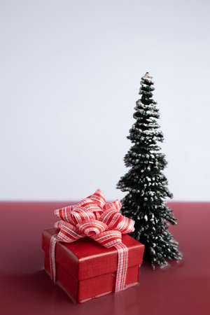 Christmas tree and wrapped gift floating on the red fluid. Beautiful festive New Year wallpaper....