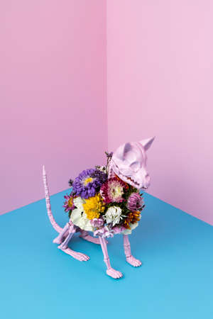 Creative Halloween layout made with skeleton and flowers on dual tone background. Creative magic surreal concept. Witch ritual atmosphere. Isometric view.の写真素材