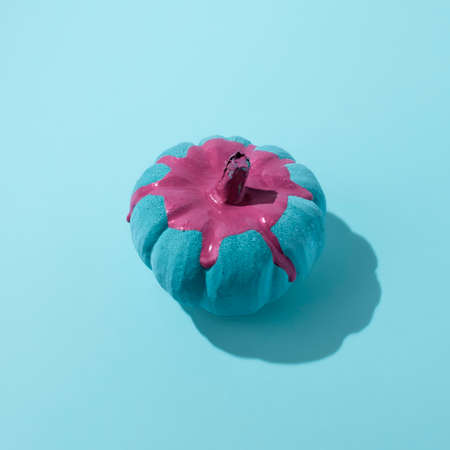 Fall layout made of decorative pumpkin with dripping paint on a blue background. Autumn, Halloween or Thanksgiving concept. Trend shadow, flat lay, top view.の写真素材