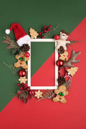 Christmas holiday layout made with gingerbread man, antlers, Santa's cap and holly berries on green...