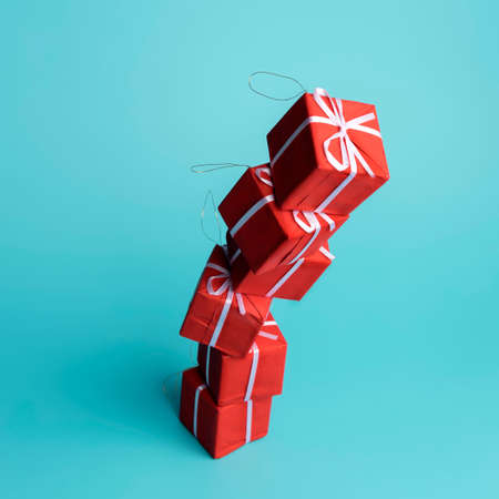 Christmas holiday decorative layout made with present ribbon wrapped gift box on blue background. Minimal winter or New Year concept with copy space. Seasonal greeting card.の写真素材