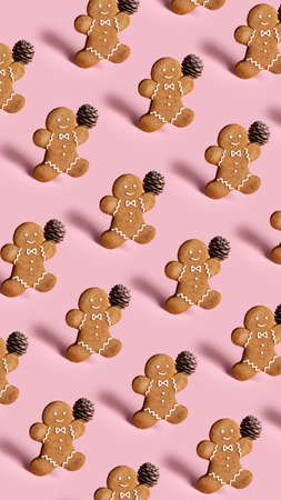 Creative Christmas pattern layout made with gingerbread man on pastel pink background. Minimal winter or New Year concept. Template for greeting card or design with copy space. Flat lay.の写真素材