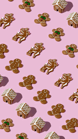 Creative Christmas pattern layout made with gingerbread man on pastel pink background. Minimal...