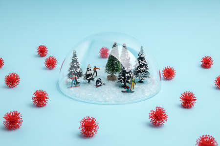Creative coronavirus layout made with snowboarders under the glass dome, surrounded by virus....