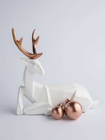 Creative Christmas layout made with white deer and rose gold bauble ornaments on bright background. Minimal New Year festive concept. Winter greeting card.の写真素材