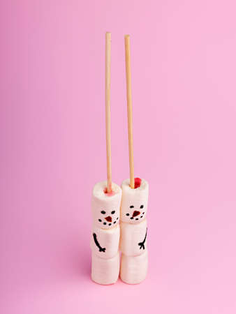Creative Christmas layout made with snowman marshmallow on pastel pink background. Minimal winter food concept. Top view, flat lay.の写真素材