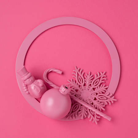Pink Christmas layout made with frame for text, ornament, candy cane and snowflake. Minimal winter or New Year seasonal concept. Flat lay, top view.の写真素材