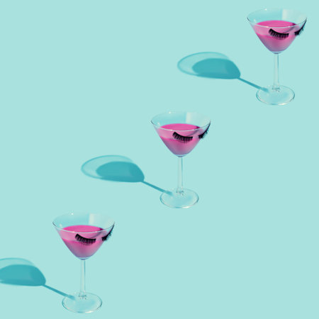 Summer stationery still life scene made with glass, pink liquid, drink, eyelashes and trend shadows on pastel background. Summer vacation refreshment concept. Long shadow and refraction pattern.の写真素材