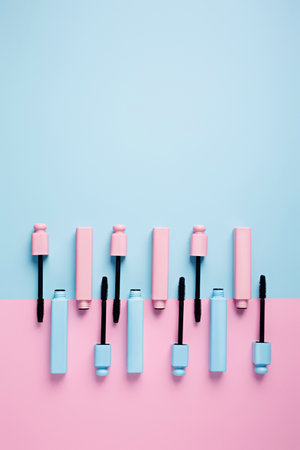 Set of professional mascara on pastel pink and blue background with copy space for text. Minimal make up, beauty, fashion, party and shopping concept. Cosmetic or beauty salon layout. Flat lay.の写真素材