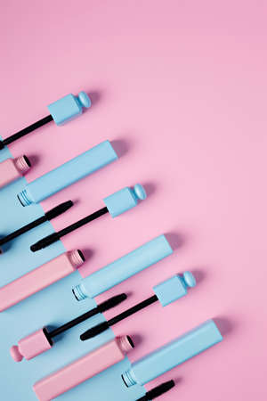 Set of professional mascara on pastel pink and blue background with copy space for text. Minimal make up, beauty, fashion, party and shopping concept. Cosmetic or beauty salon layout. Flat lay.の写真素材