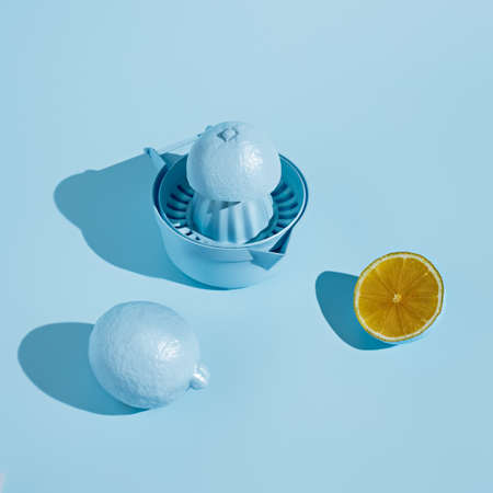 Monochrome layout with blue colored lemon and squeezer on pastel background. Minimal citrus fruit concept. Making of fresh summer juice.の写真素材