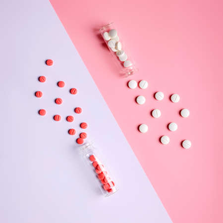 Creative layout with pills and bottle on pastel two tone pink and violet art background. Minimal pharmacy medical treatment concept. Top view, flat lay, copy space.の写真素材