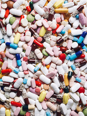 Background made with many different colorful medication and pills. Creative health care of pharmaceutical concept. Close up of heap of capsules. Flat lay, top view.の写真素材