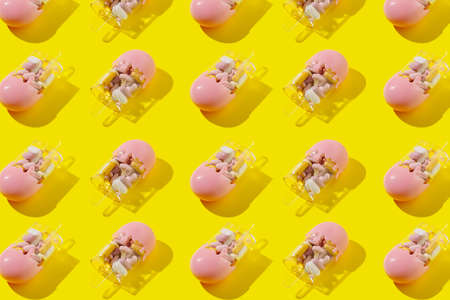 Creative pattern with ice cream filled with various pills and tablets on bright yellow background....