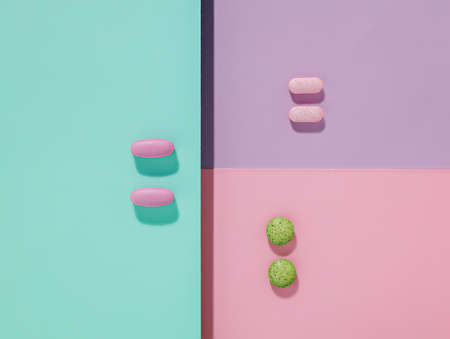 Geometric arranged pills and capsules on multi colored background. Contemporary health care or...