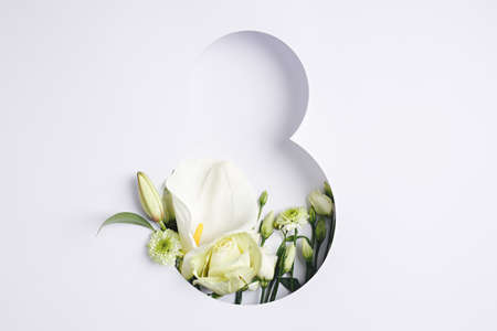 Number 8 with fresh gerbera, calla and rose flowers with green leaves on bright white background....