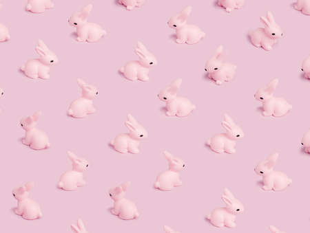 Easter pattern with pink bunny on a pastel pink background. Creative minimal holiday concept. Flat...