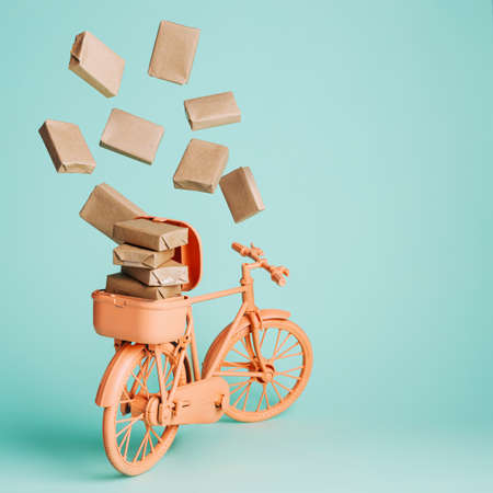 Retro orange bicycle with box packages flying around isolated on turquoise background. Creative...
