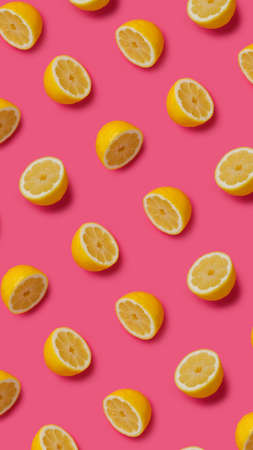 Summer food pattern made with fresh lemons on vibrant pink background. Creative fruit and vegetable texture concept. Healthy vegetarian diet composition.の写真素材