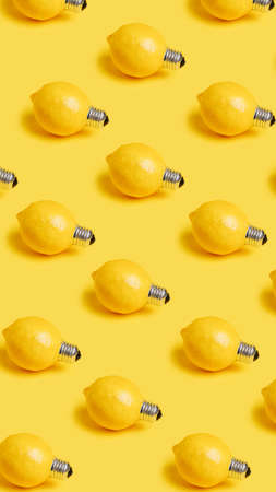 Pattern with fresh lemons as bulbs isolated on a yellow background. Creative food recipe idea. Abstract and surreal fruit health diet concept. Flat lay, top view.の写真素材