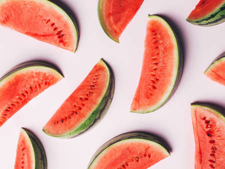 Pattern of watermelon slices isolated on a pastel pink background. Ripe and sweet summer refreshing...
