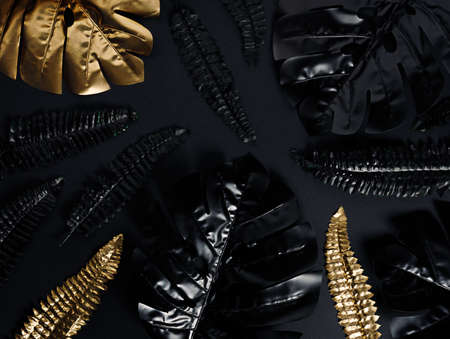 Creative layout made of tropical leaves on black background. Flat lay, top view.の写真素材