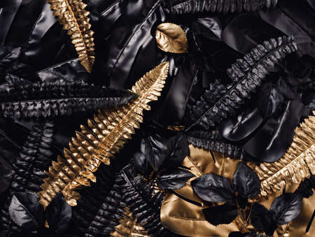 Texture made with gold and black fern and monstera leaves. Creative natural concept. Tropical palm leaves pattern. Flat lay, top view.の写真素材