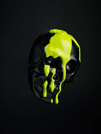Black human skull with leaking and dripping neon green paint isolated on a black background. Creative Halloween or Santa Muerte concept. Retro future aesthetic.の写真素材
