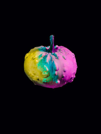 Fluorescent iridescent pumpkin isolated on a dark black background. Creative Halloween party or Thanksgiving concept. Fall season vegetable. Trendy vaporwave creative gradient.の写真素材