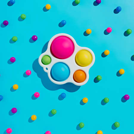 Top view of multicolored antistress toy on blue background