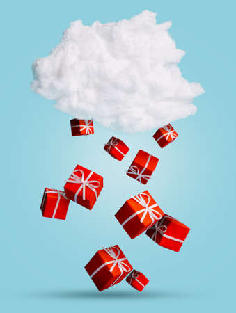 Red Christmas present gifts falling and snowing from the white cloud on pastel blue background....