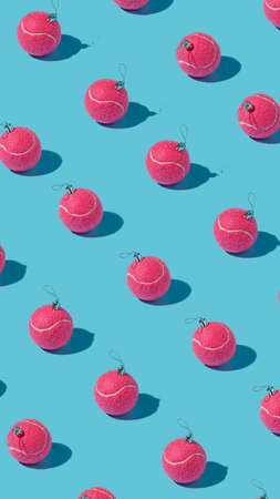 Creative Christmas pattern made with flying pink tennis balls as a tree ornament vibrant red on...