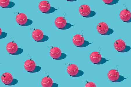 Creative Christmas pattern made with flying pink tennis balls as a tree ornament vibrant red on...