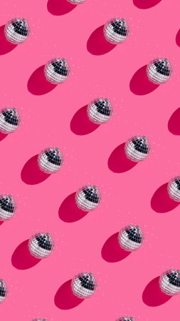 Creative Christmas party pattern made with shiny disco balls on vibrant pink background. Minimal Xmas or New Year eve celebration concept. Minimal winter holidays idea. Contemporary wallpaper.の写真素材