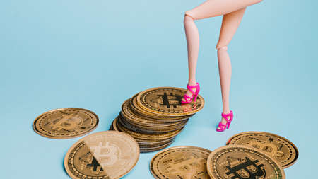 cropped view of woman in pink shoes standing near bitcoins on blueの写真素材