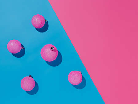 Pink christmas balls on blue and pink background. Minimal holiday concept.の写真素材
