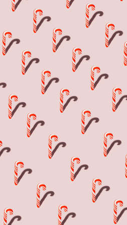 Pattern with Christmas candy canes on pastel pink background. Getting ready for the New Year. Creative Holiday season concept. Festive candies and sweet food. Minimal creative texture art. Flat lay.の写真素材