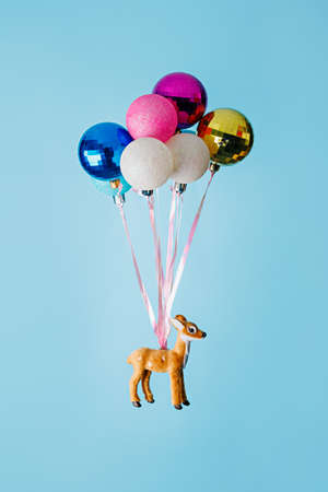 Colorful balloons and reindeer on a blue background. Minimal concept.の写真素材