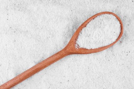 Rock salt in a wooden spoon on a background of saltの写真素材