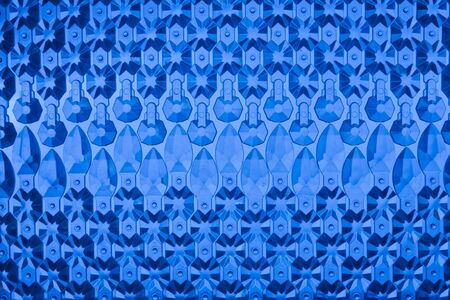 Glass elements are laid out on a blue background