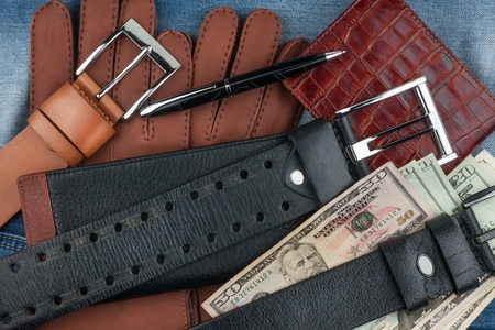 Pen, gloves, purses, belts and money on jeans backgroundの写真素材
