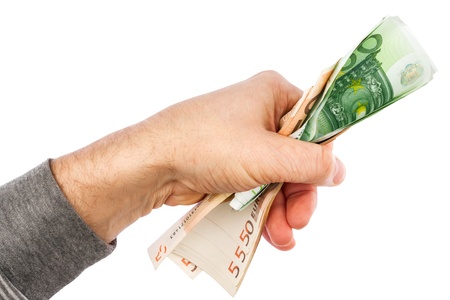 Hand grasps the euro, isolated on white backgroundの写真素材