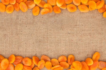 Dried apricots are lying on sackcloth with space for textの写真素材