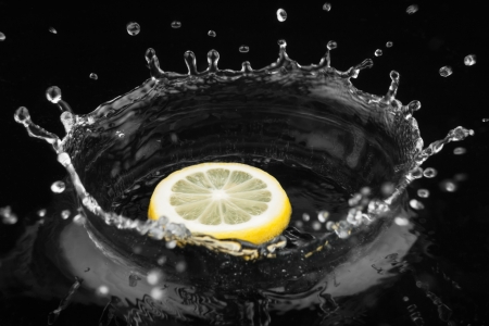 Lemon falls into water on black backgroundの写真素材